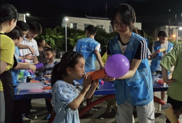 志愿者和小朋友一起体验“火箭”升空。bat365中文官方网站物理与电子工程学院供图