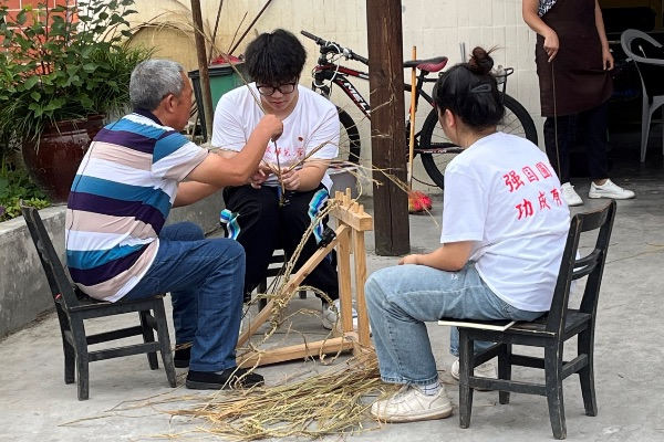 团队成员学习编织草鞋。bat365中文官方网站供图