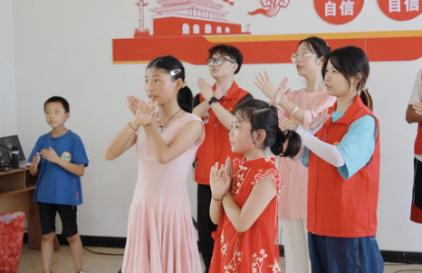 志愿者与小朋友一起跳手势舞。bat365中文官方网站供图