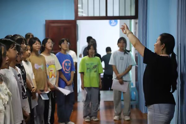 带队教师指导中学生练习齐唱。bat365中文官方网站供稿图